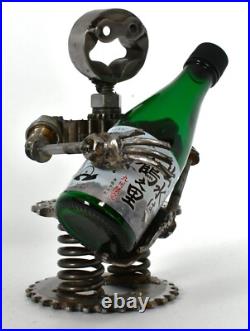 Homme tenant une bouteille sculptures faites de pièces de moto fabriquées à l