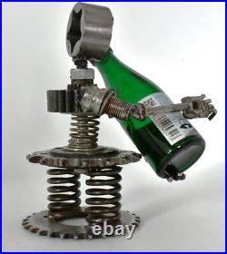 Homme tenant une bouteille sculptures faites de pièces de moto fabriquées à l