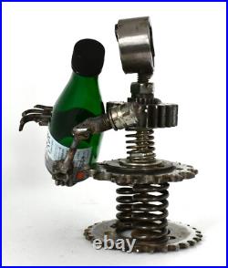 Homme tenant une bouteille sculptures faites de pièces de moto fabriquées à l