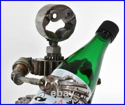 Homme tenant une bouteille sculptures faites de pièces de moto fabriquées à l