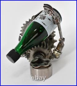 Homme tenant une bouteille sculptures faites de pièces de moto fabriquées à l