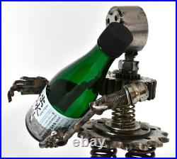Homme tenant une bouteille sculptures faites de pièces de moto fabriquées à l